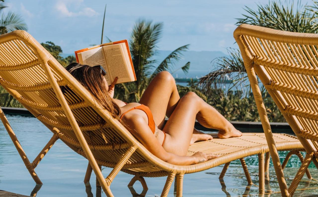 Neano Escape Ξενοδοχείο Manggis Εξωτερικό φωτογραφία A woman reading a book on a beach